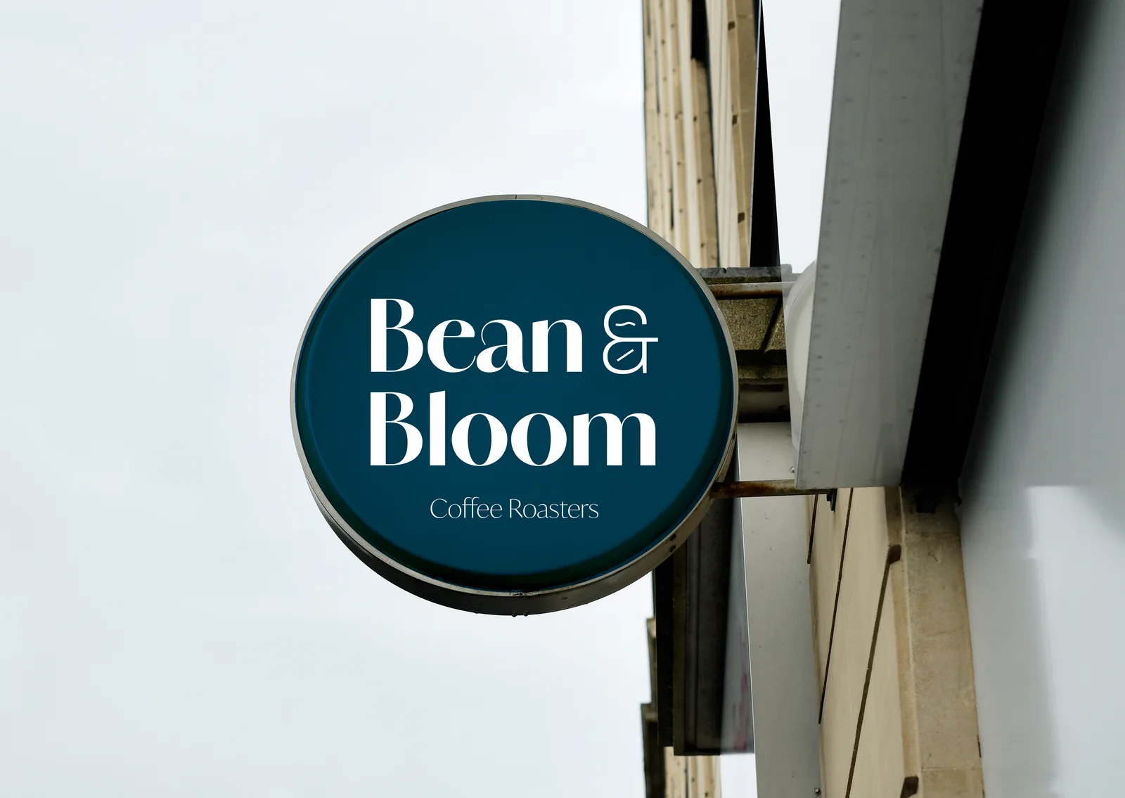 Round Bean & Bloom shop sign on a building